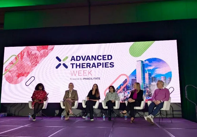 A group of women are sitting on a stage at advanced therapies week.