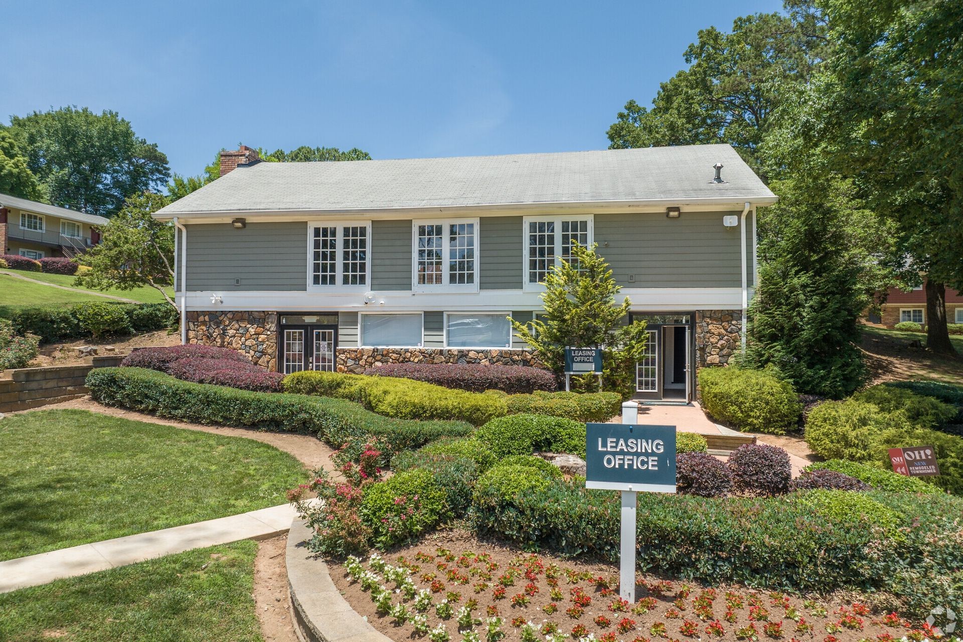 Two-story building with a sign in front that says 