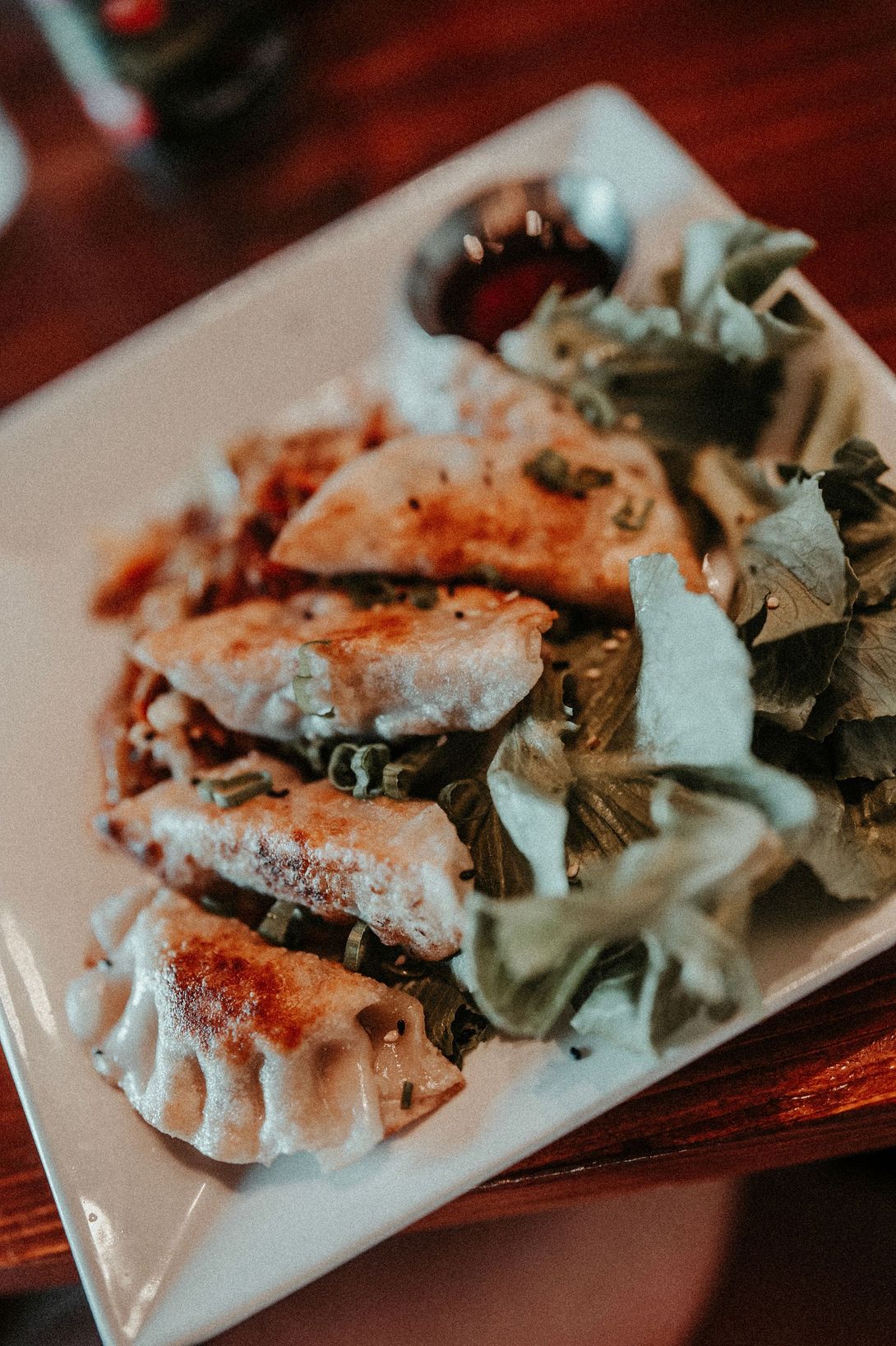 Plated grilled fish with rice and greens on a white rectangular dish