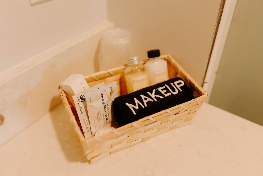 A makeup organizer tray with cosmetics and bottles on a bathroom counter next to a wall.