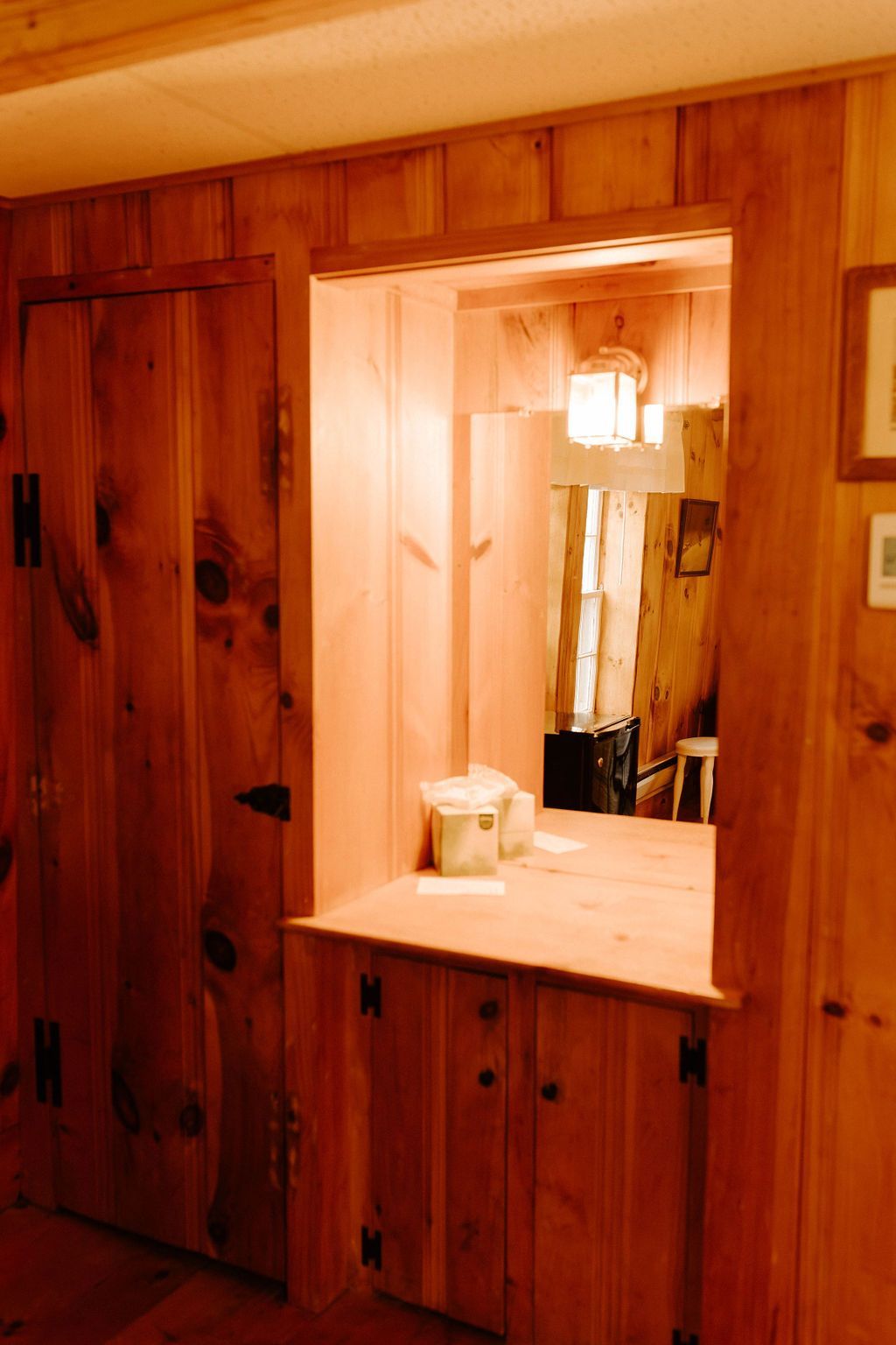 Wood-paneled bathroom vanity with mirror, sink, and warm lighting