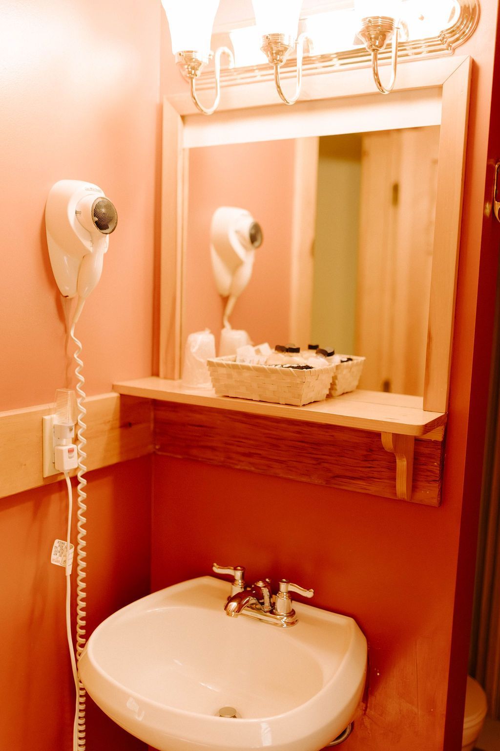 Small bathroom vanity with wall-mounted mirror, white sink, and cream walls.