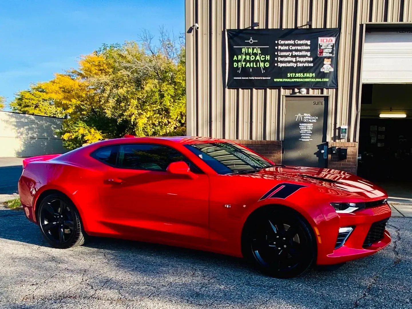 a red car is parked in front of a building .
