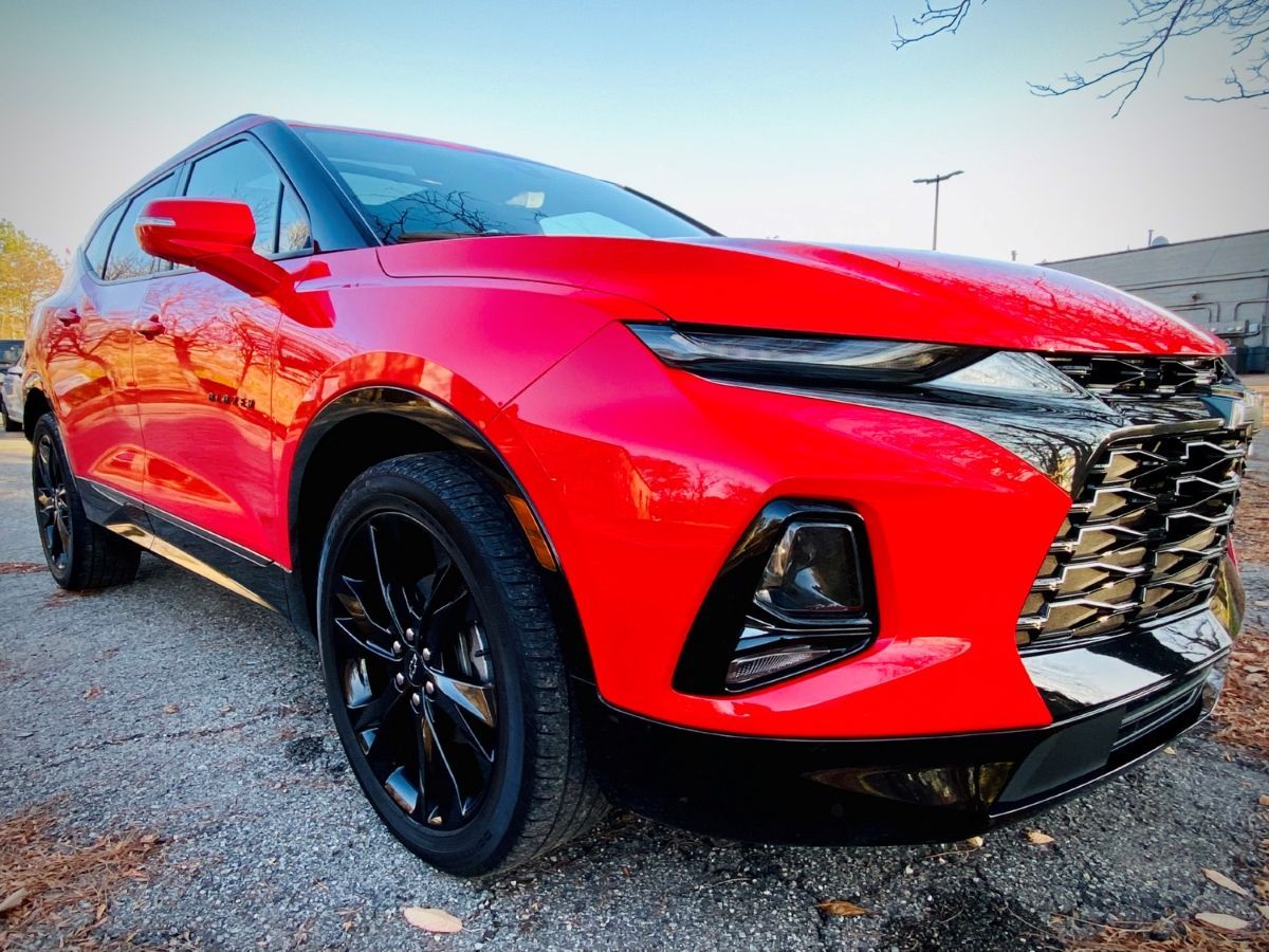 a red chevrolet blazer is parked in a parking lot .