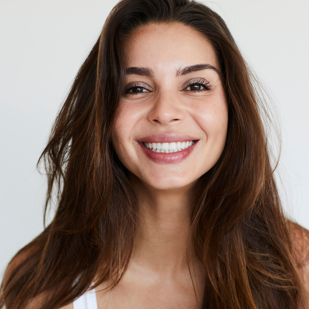 A woman with long brown hair is smiling for the camera