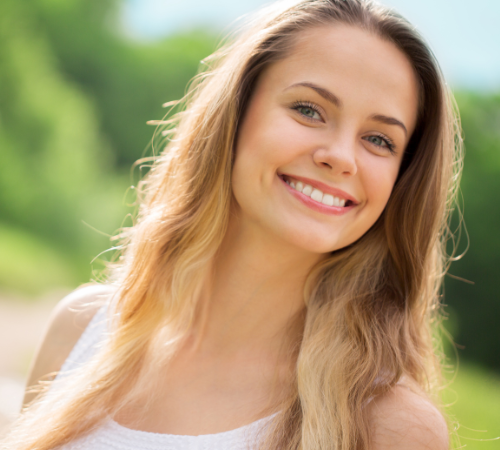 A woman with long blonde hair is smiling for the camera