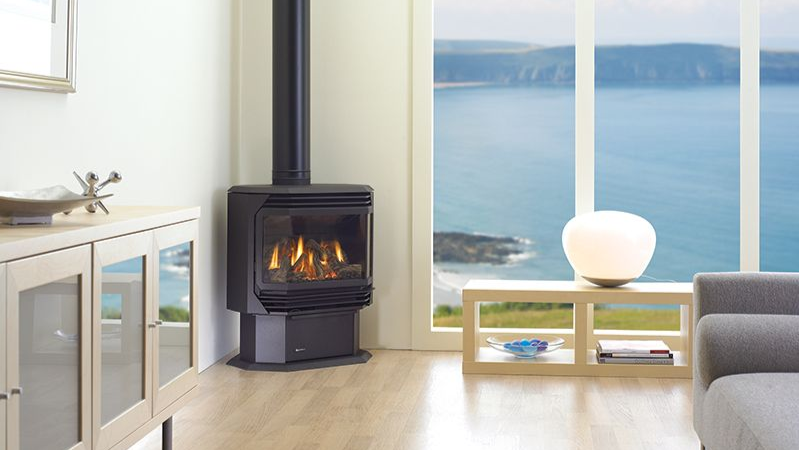 Freestanding gas stove heating a modern waterfront living space with efficient flame display.