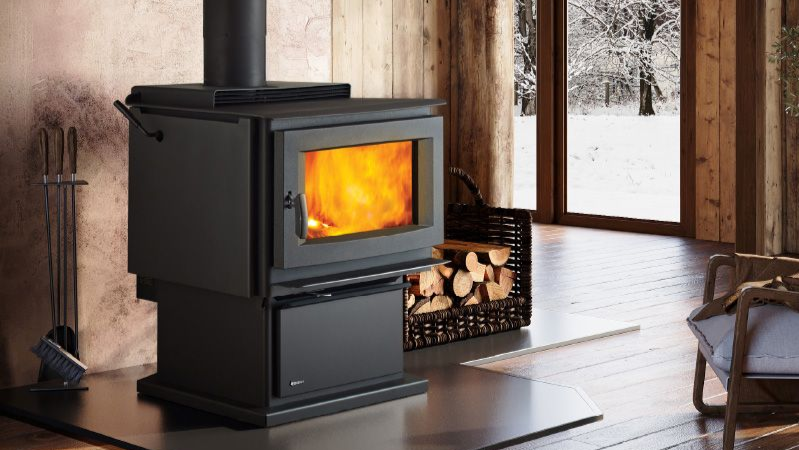 Freestanding wood stove providing dependable heat inside a rustic Northwest-style living space.