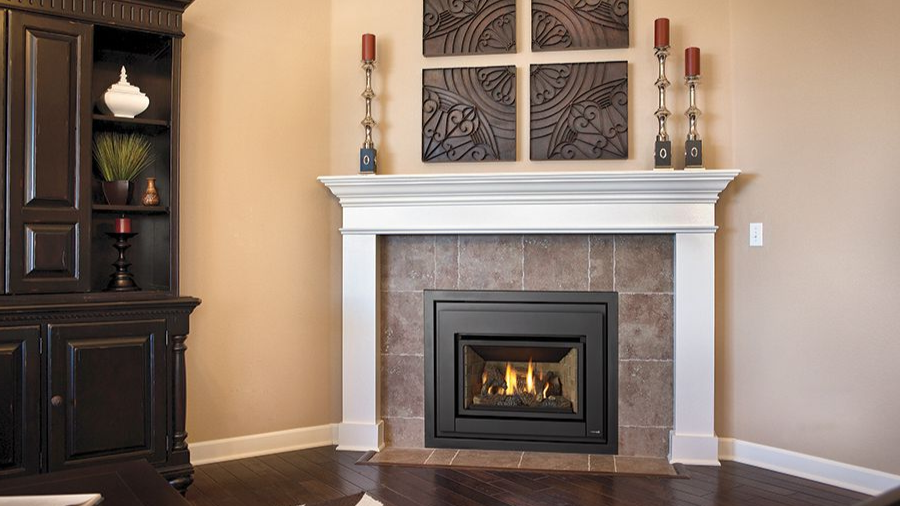 Traditional gas fireplace insert installed inside an existing masonry fireplace with mantel surround.