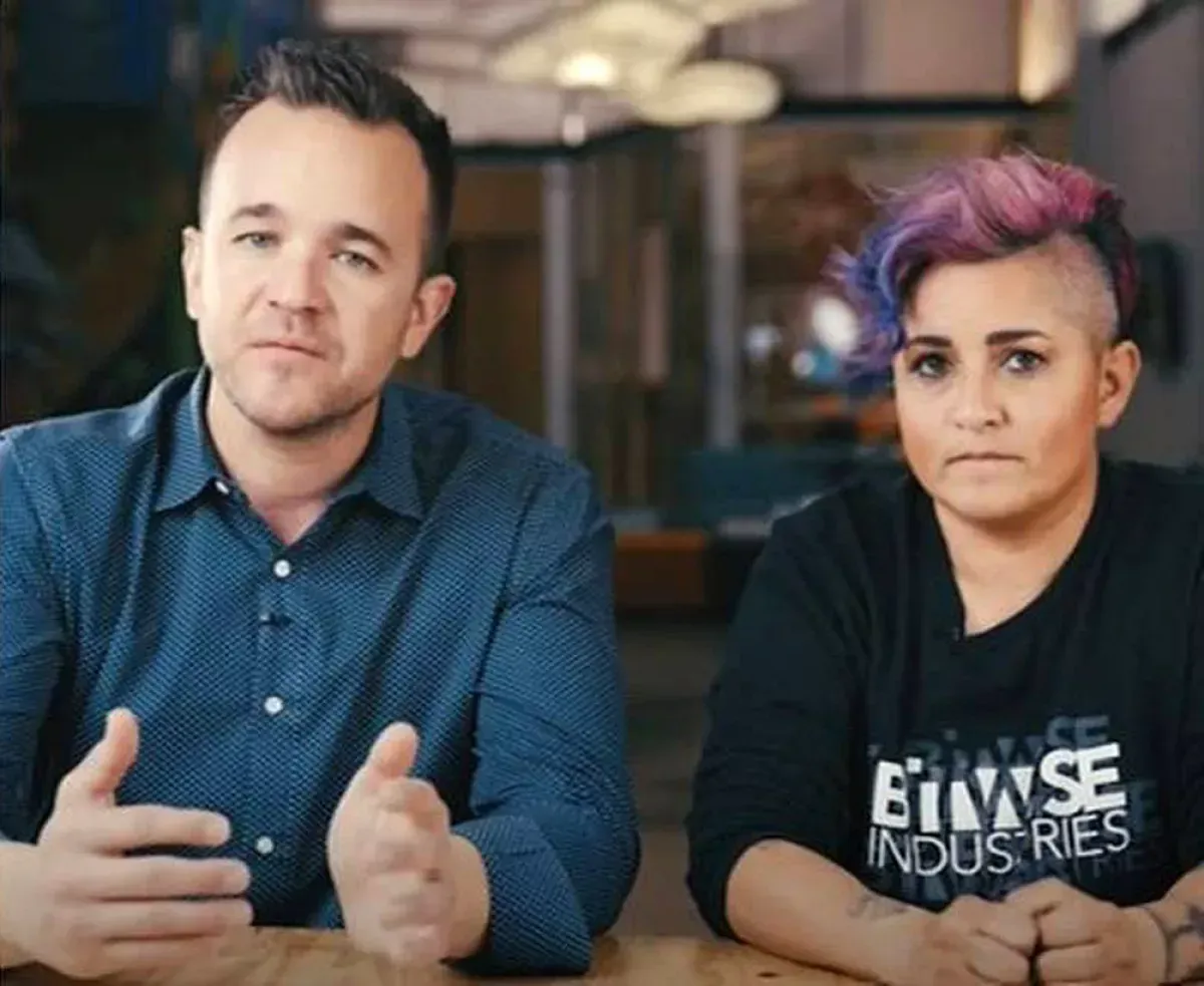 A man and a woman are sitting at a table wearing eclipse industries shirts