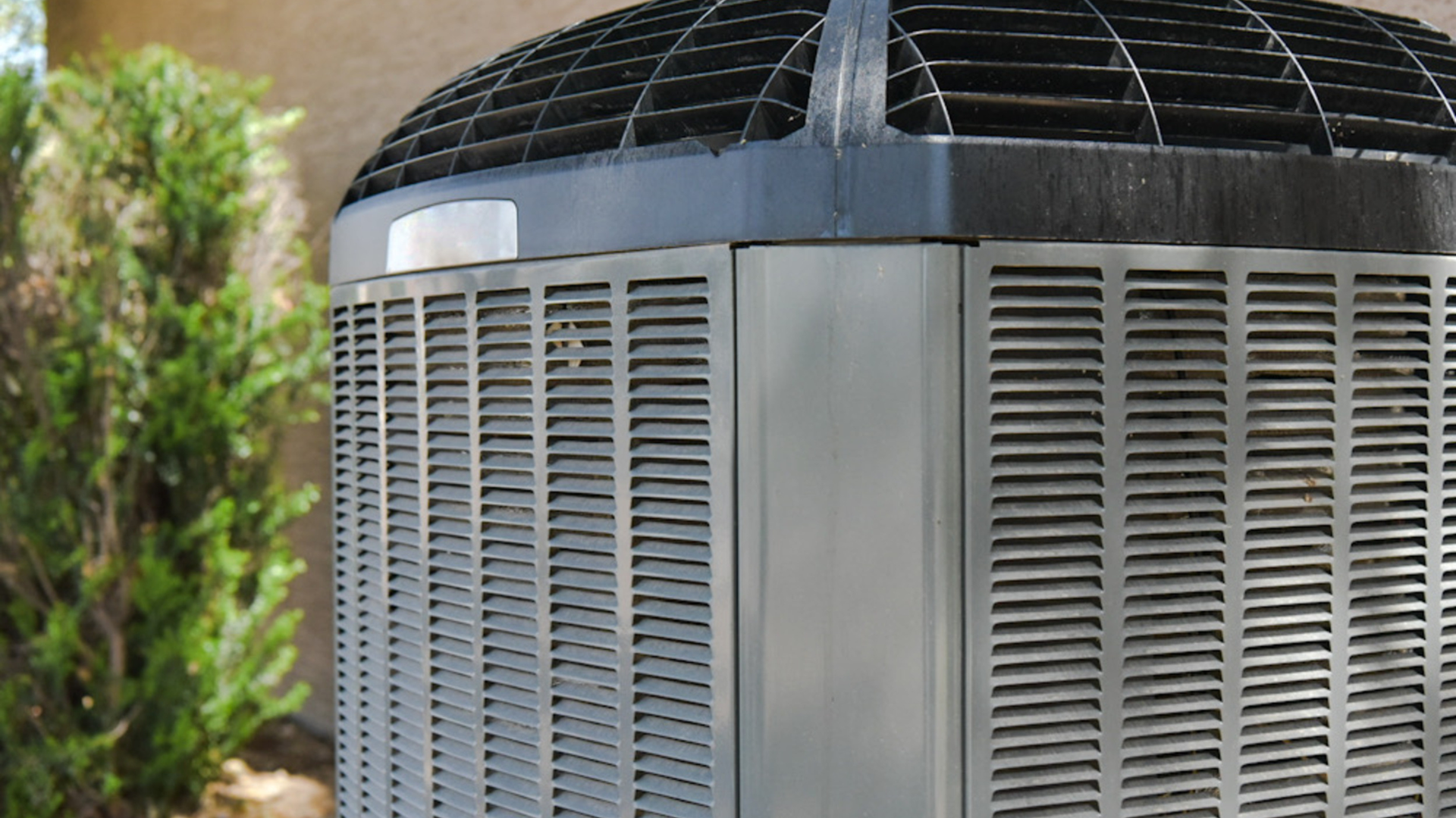 Air conditioning units with toolbox and gloves in backyard.