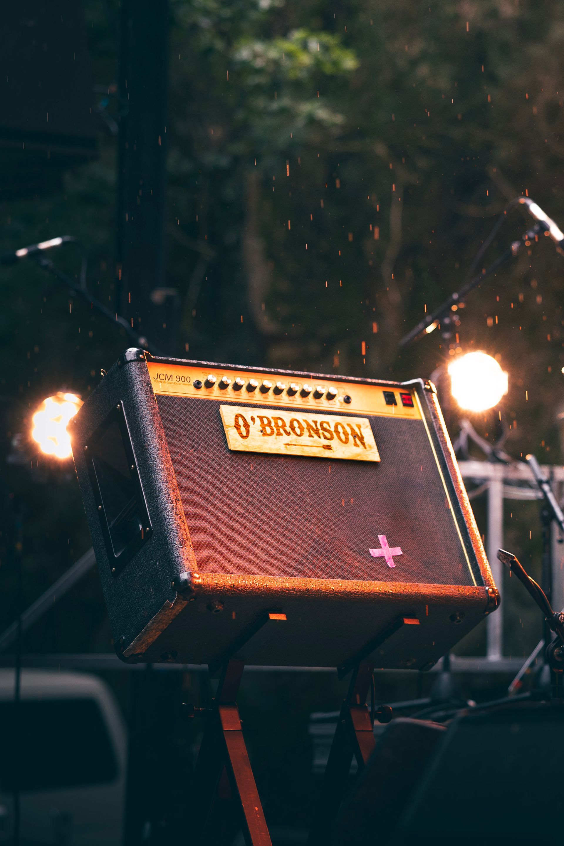 Un amplificateur de guitare orange sur scène, avec des lumières vives en arrière-plan.