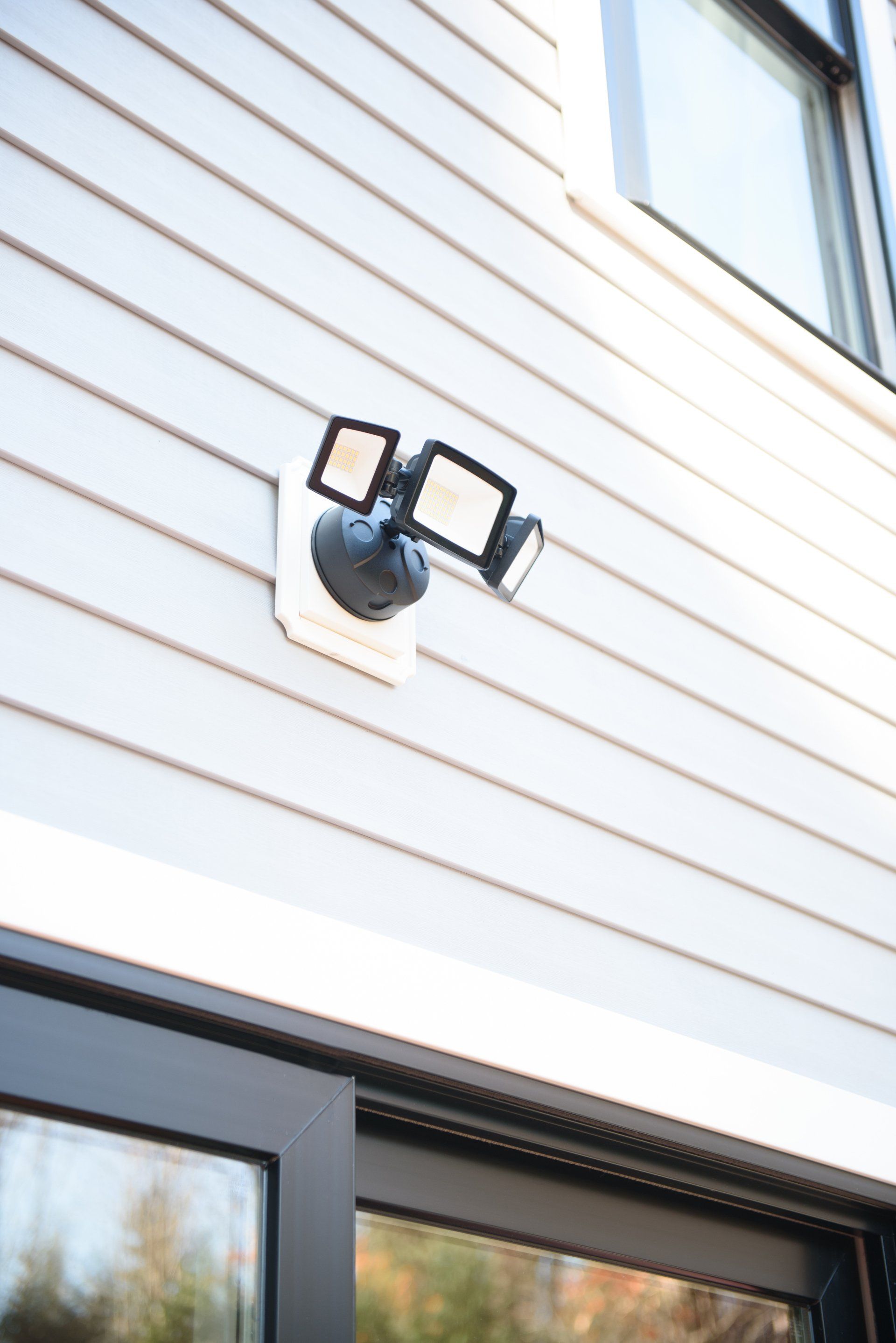 A close up of a security light on the side of a house.