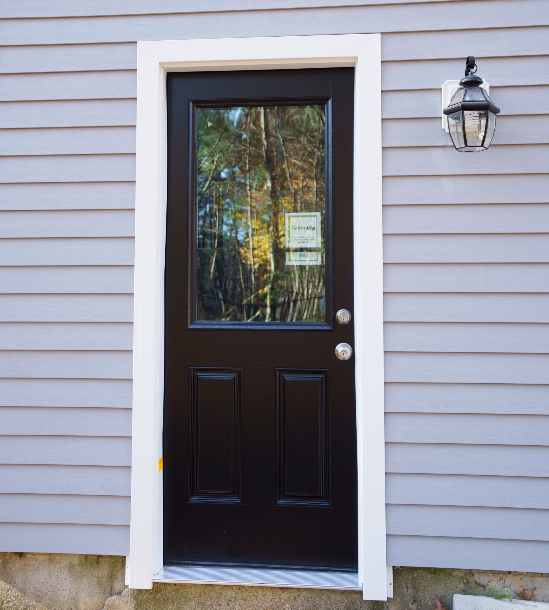A black door is on the side of a house