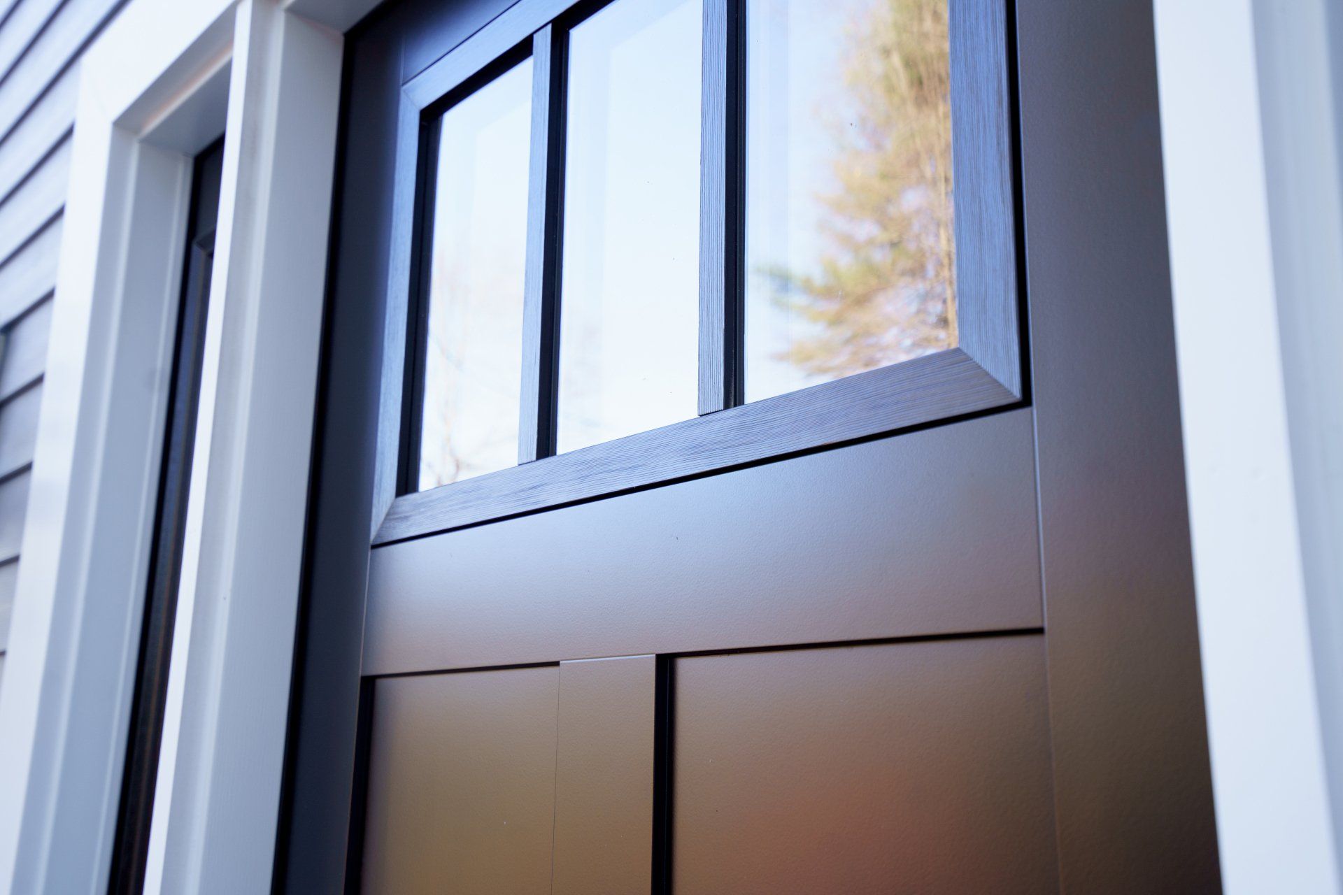A close up of a black door on a white house