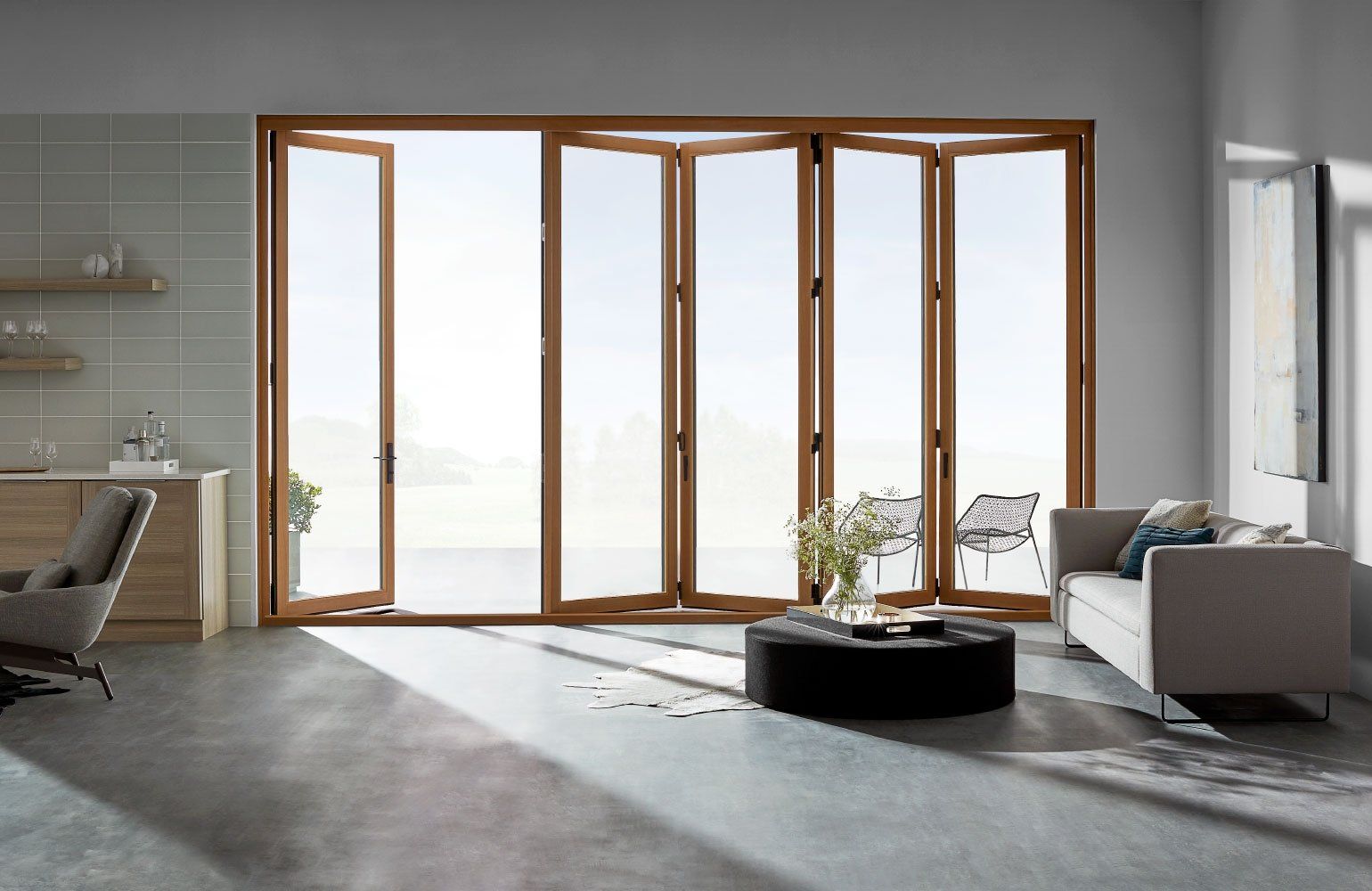 A living room with a couch , chair , coffee table and large windows.