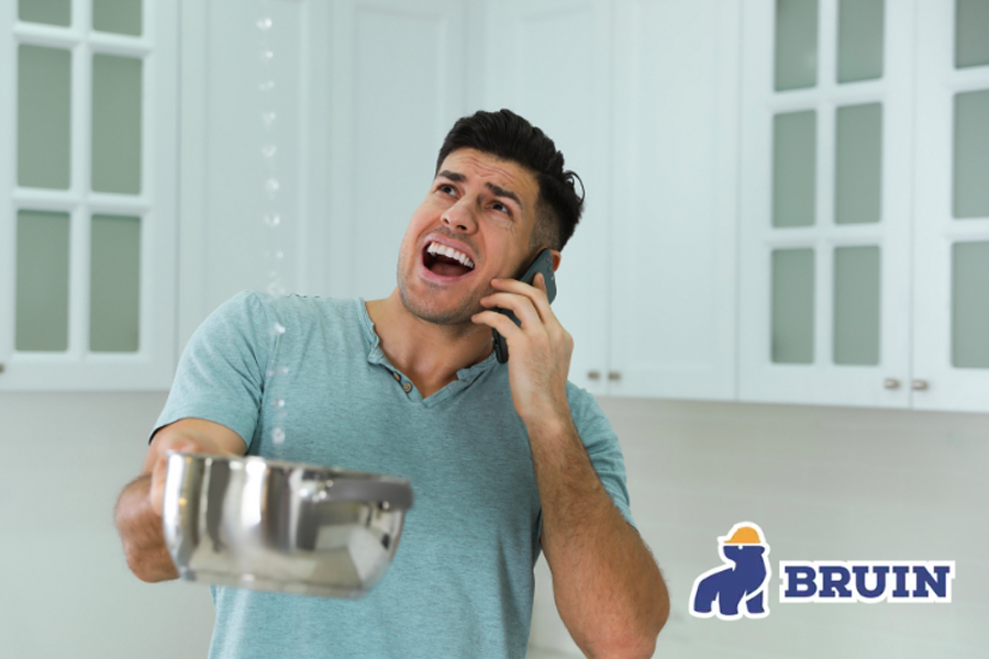A man is talking on a cell phone while holding a pot.
