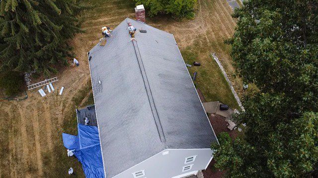 An aerial view of a house with a roof being installed.
