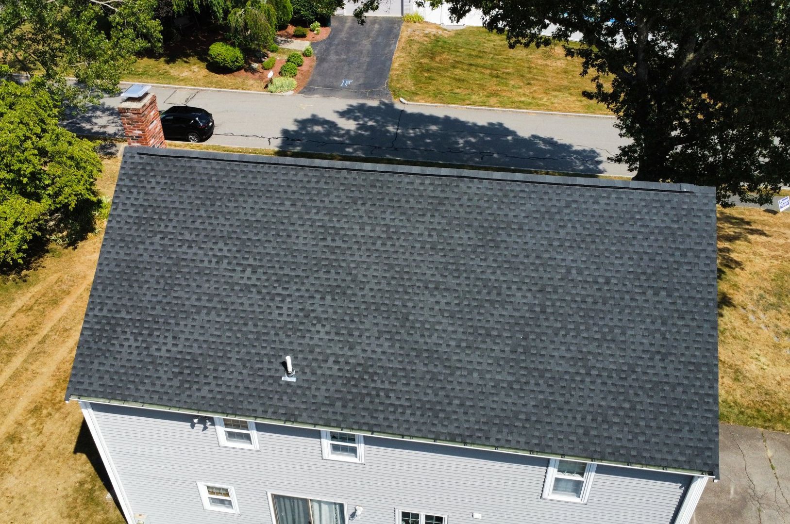 An aerial view of a house with a black roof.