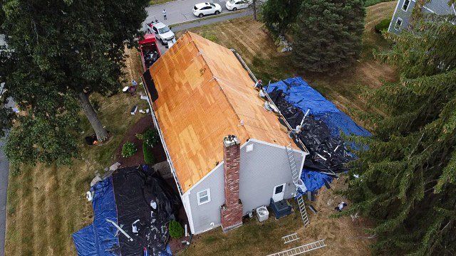 An aerial view of a house with a new roof being installed.