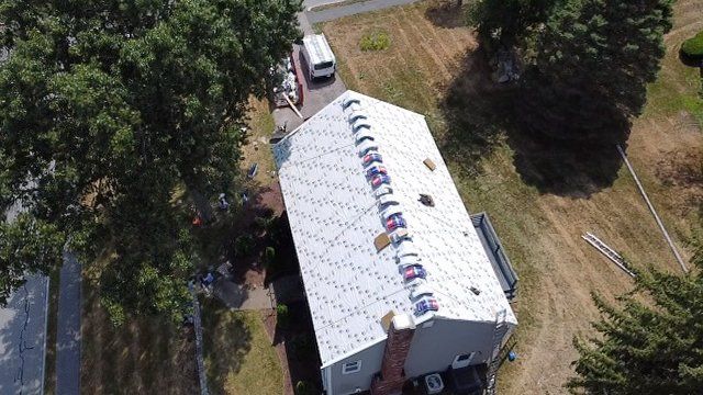 An aerial view of a house with a new roof being installed.