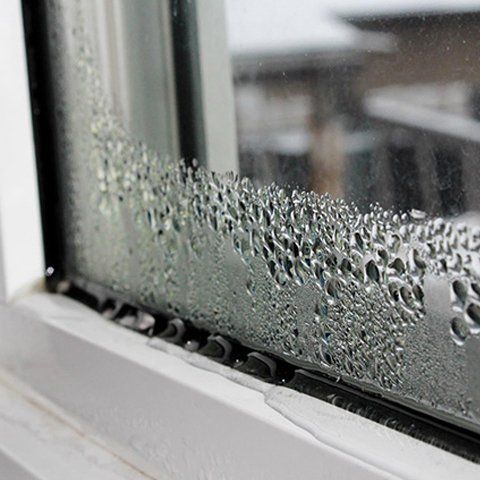 A close up of a window with condensation on it.