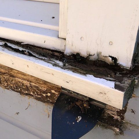 A close up of a window sill with peeling paint