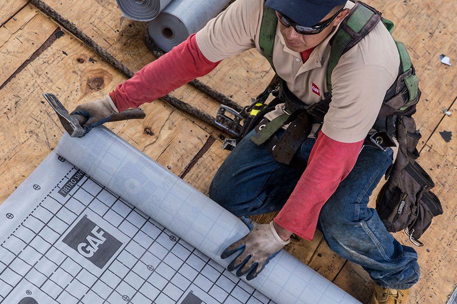 A man is working on a roof with a hammer.