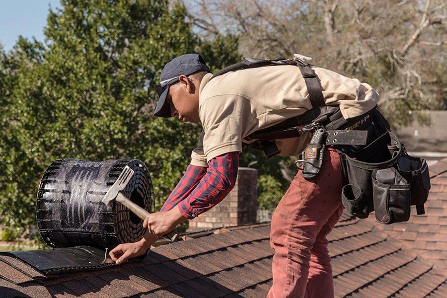 A man is working on a roof with a hammer.