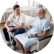 Doctor talking with a seated patient in a bright clinic room.