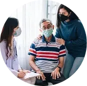 Healthcare worker consulting with a masked patient while another clinician takes notes