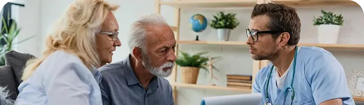 Three people in a bright office talking closely, with plants and a globe in the background.