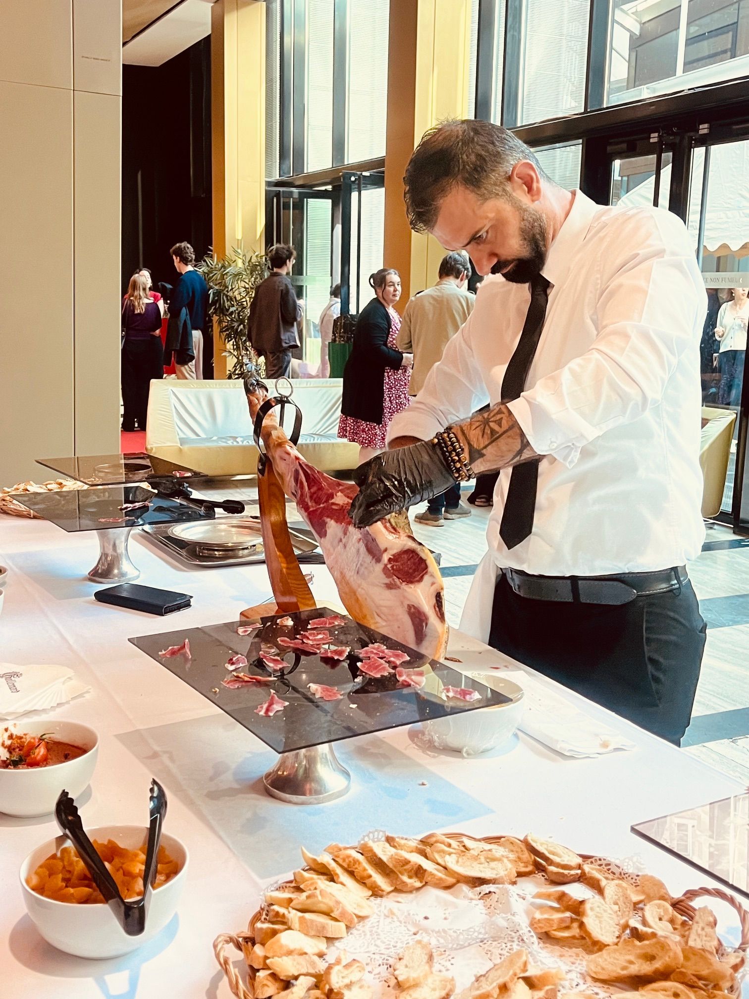 Un chef découpe de la viande sur un buffet entouré de plats tranchés et de hautes décorations.
