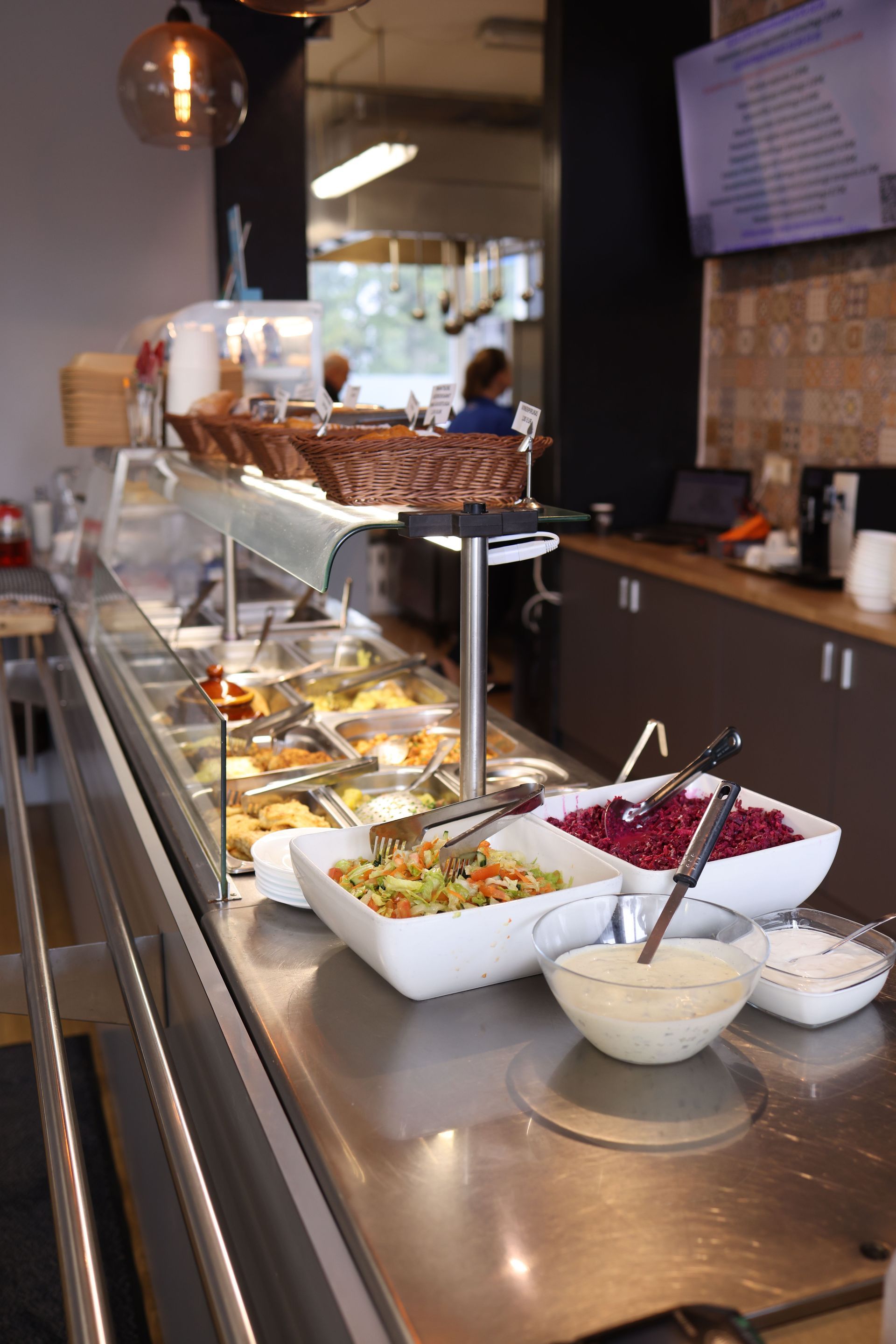 Comptoir buffet avec salades et plats chauds dans une cafétéria moderne