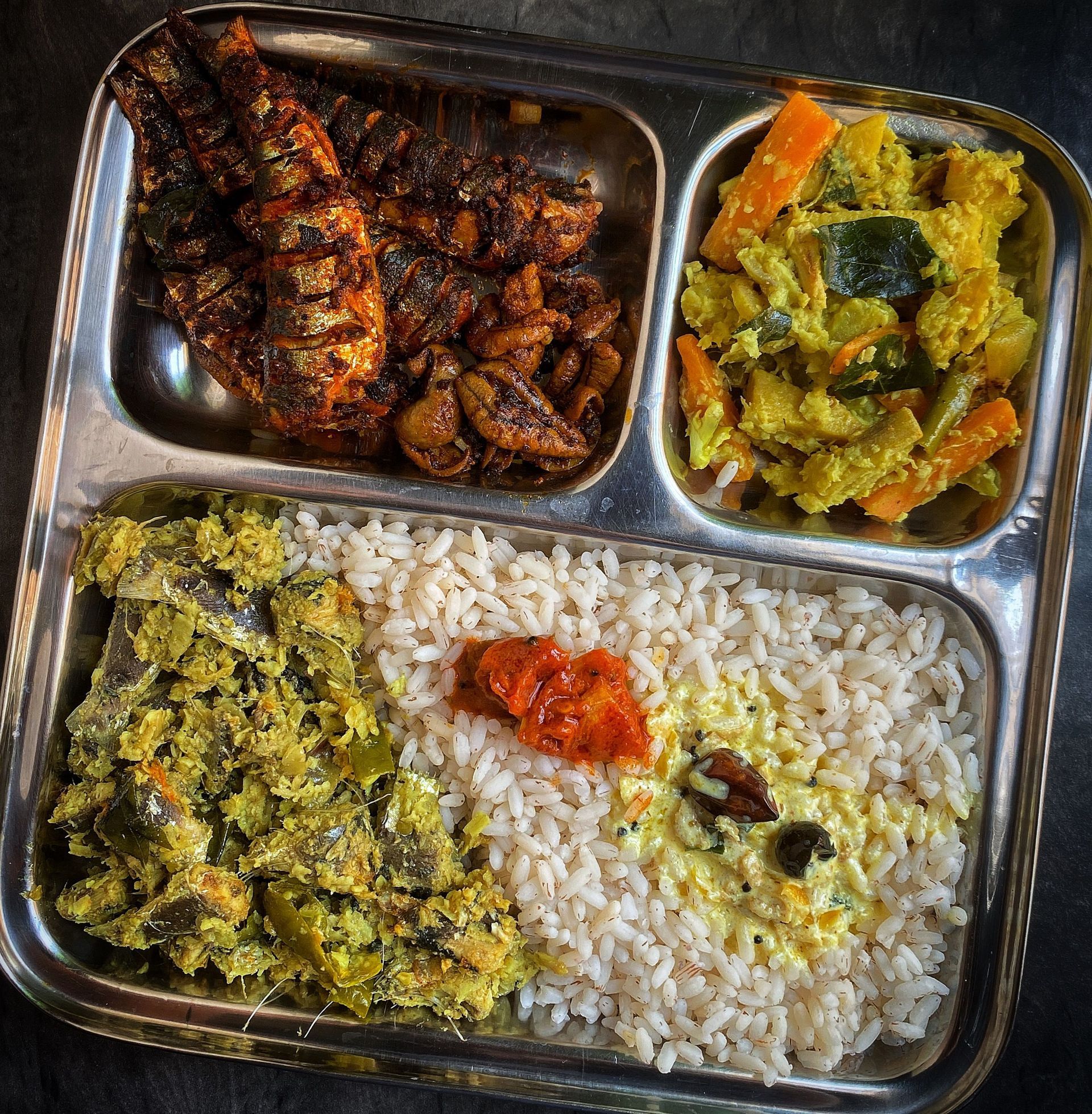 Plateau-repas en acier avec riz, curry et deux accompagnements de légumes