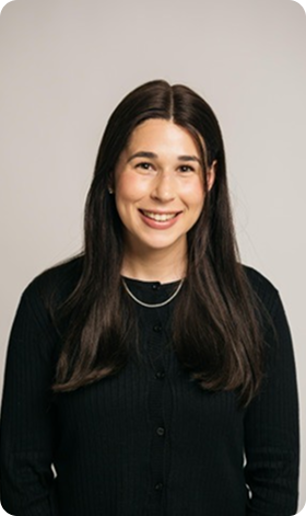 Woman with long dark hair smiles, wearing a black top and a small necklace.