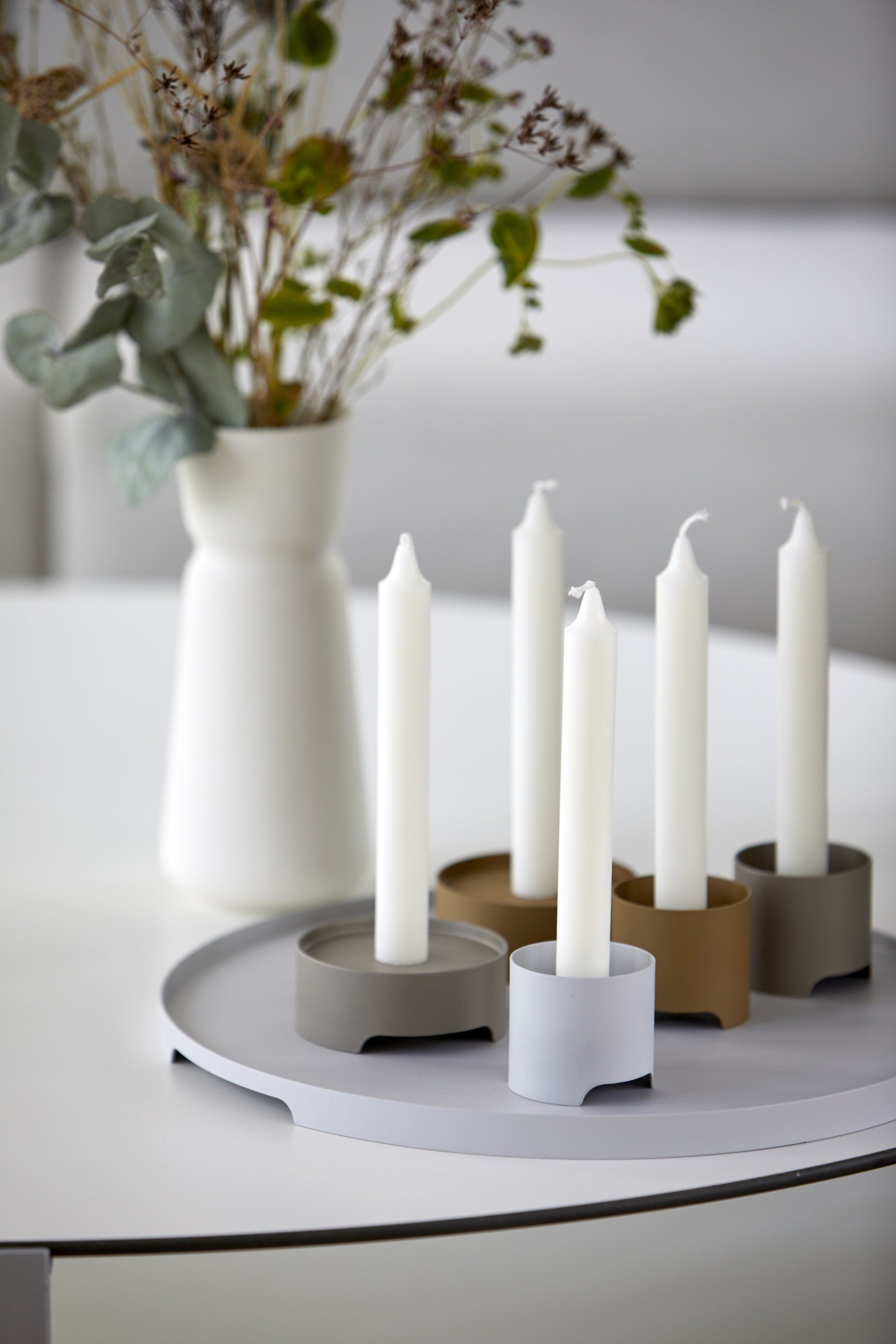 Ein Tisch mit Kerzen und einer Vase mit Blumen darauf