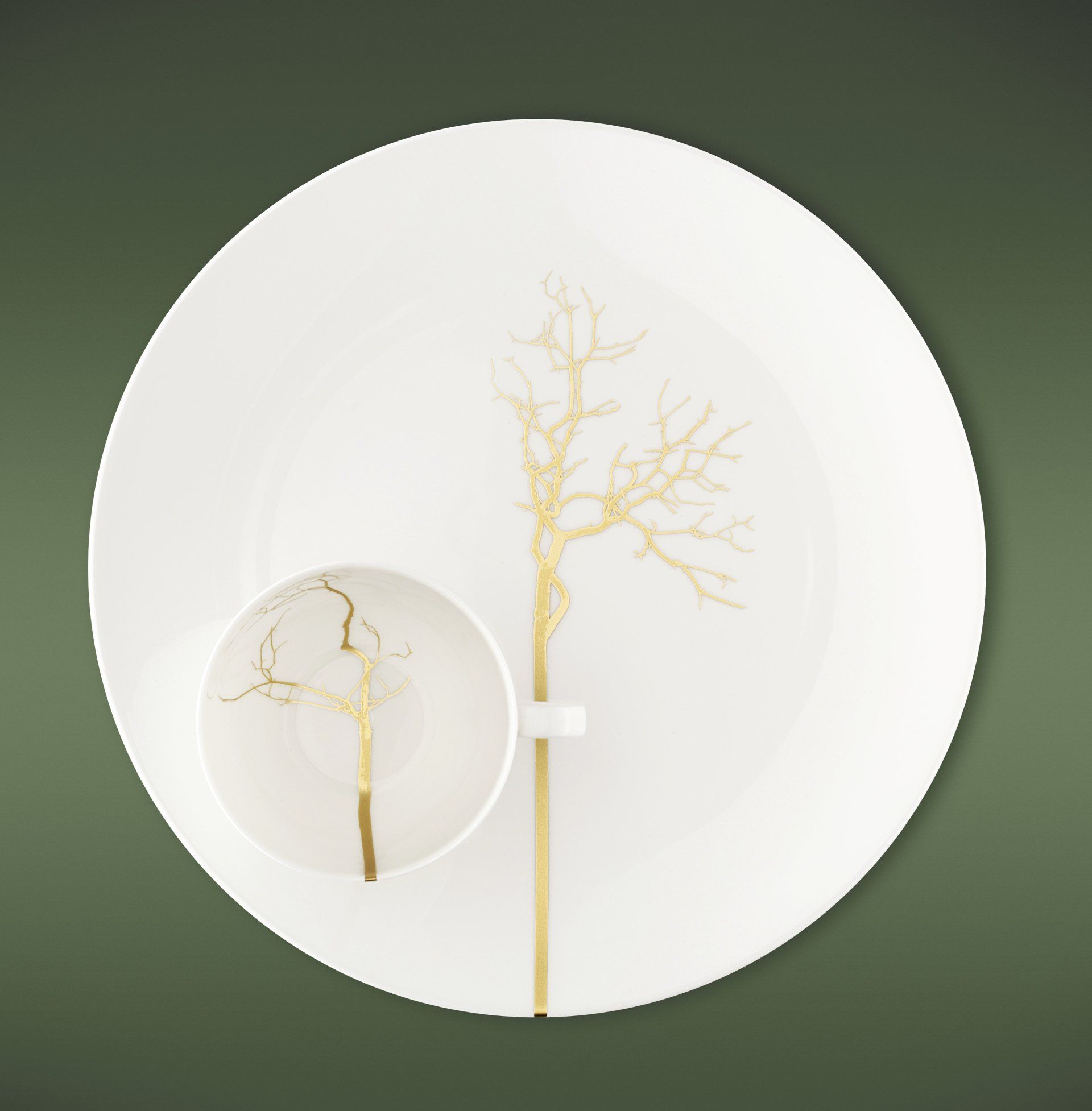 Ein weißer Teller mit einem goldenen Baum darauf