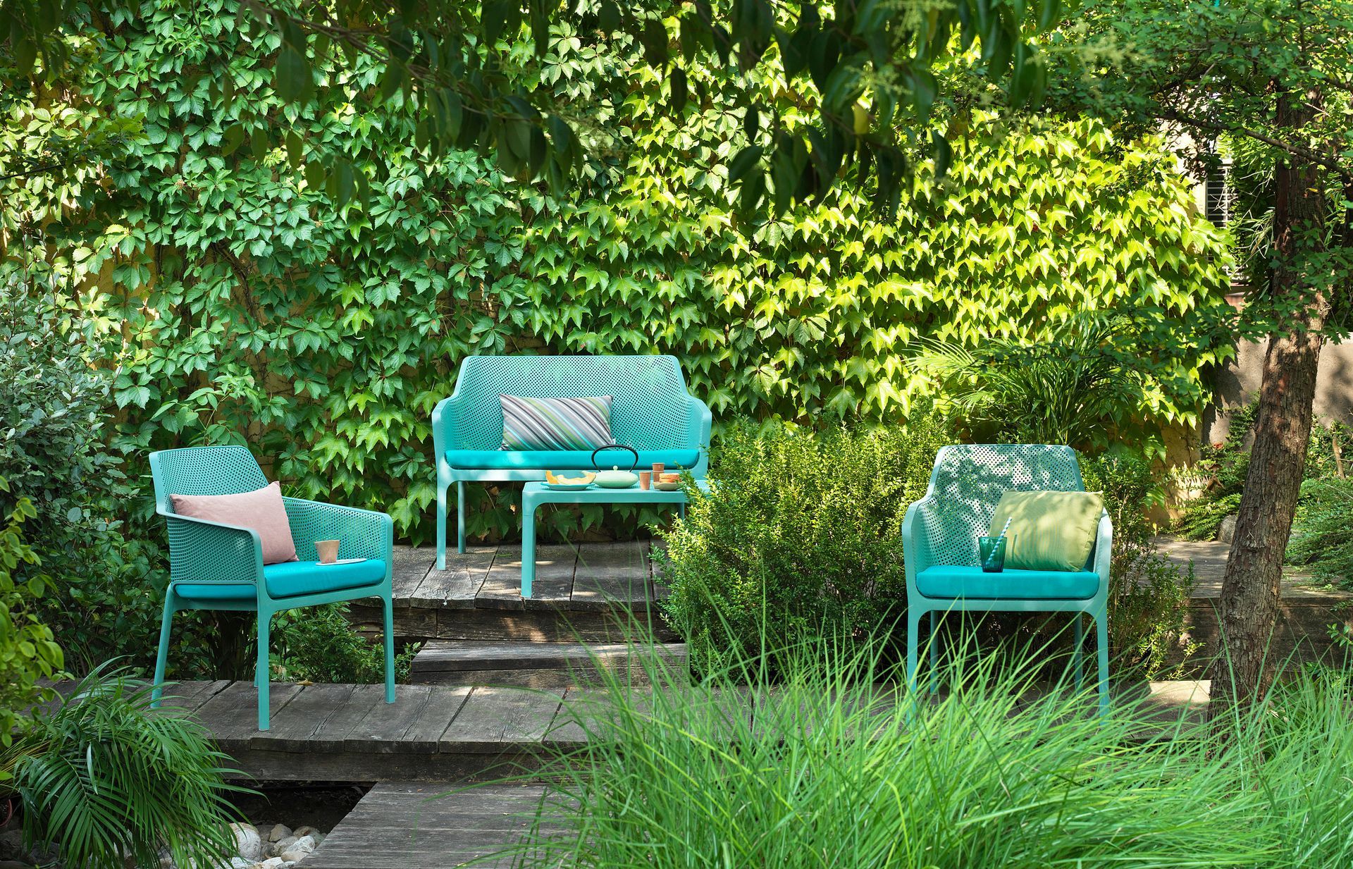 Ein Garten mit Couch, Stühlen und Tisch.