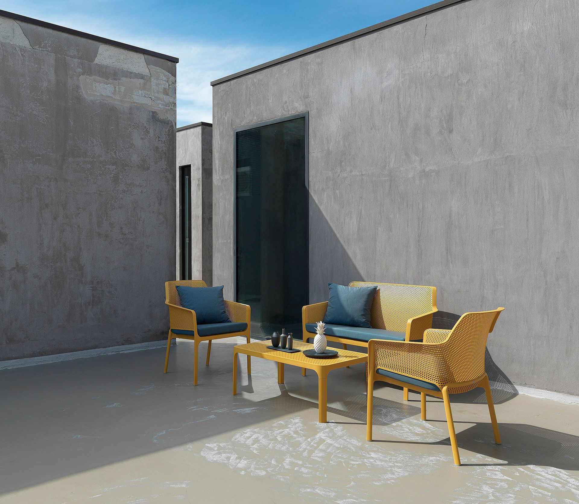 Eine Terrasse mit Sofa, Stühlen und einem Tisch