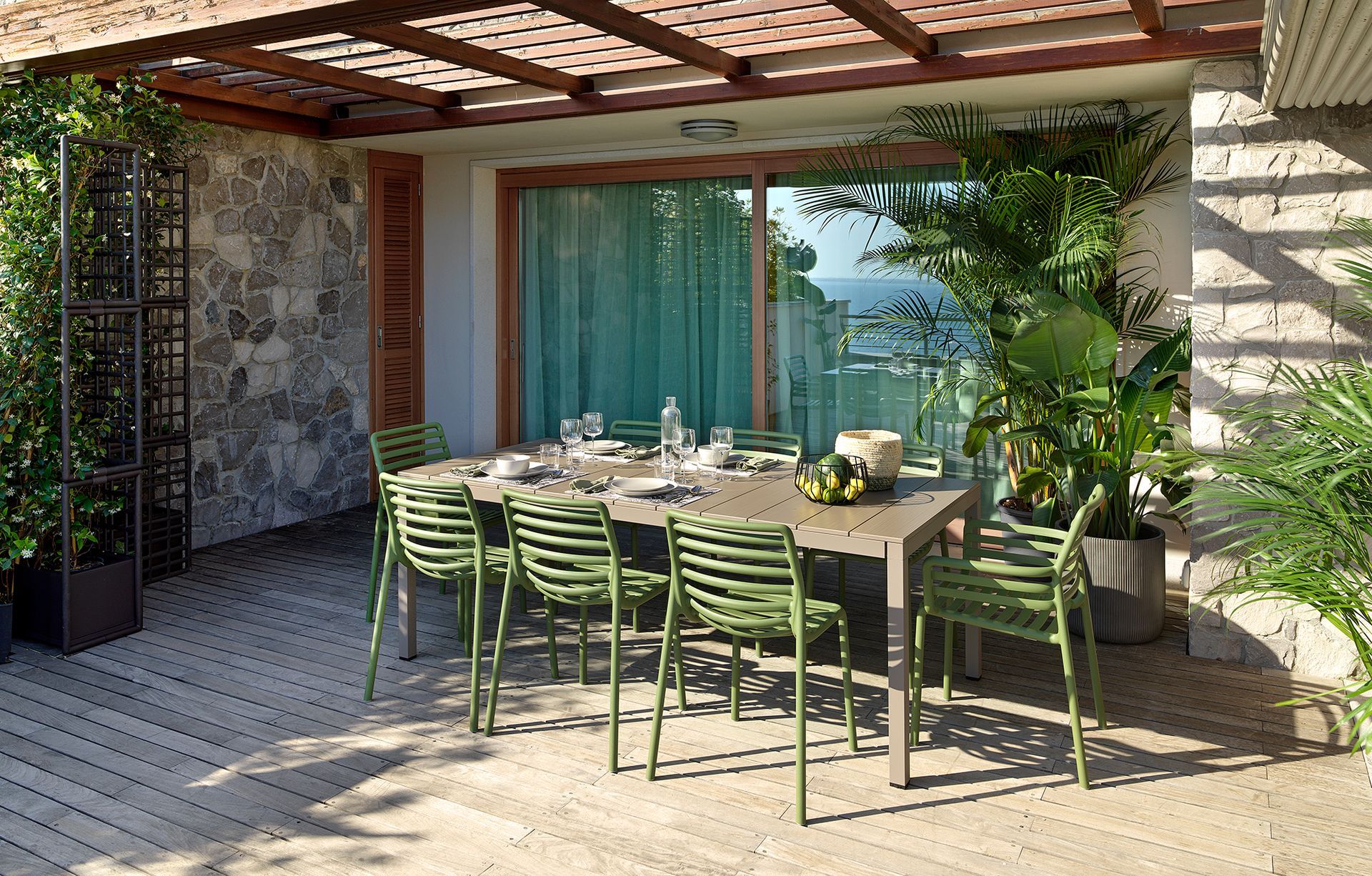 Eine Terrasse mit Tisch und Stühlen unter einer Pergola.