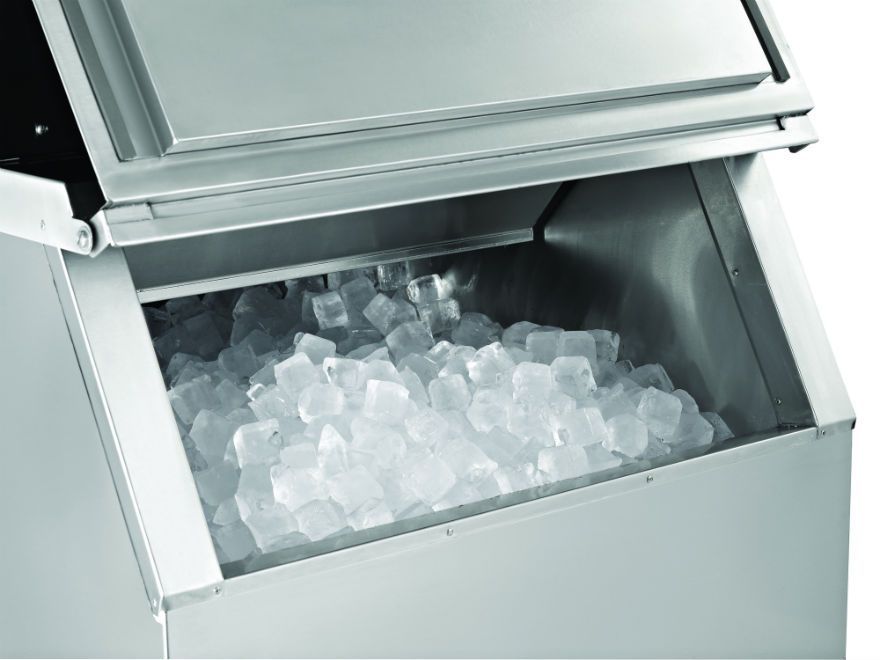 a stainless steel ice maker filled with ice cubes .