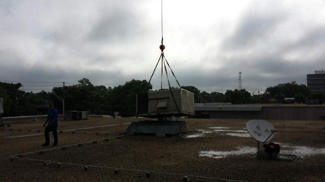 a crane is lifting a box on top of a building
