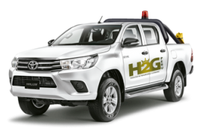 Camioneta Toyota blanca con el logotipo H2G y luces en el techo sobre un fondo blanco.