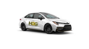Coche sedán blanco con el logotipo de HCG en el lateral, aislado sobre un fondo blanco.