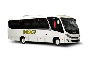 Minibús blanco de pasajeros con ventanas tintadas y el logotipo de H2O sobre un fondo blanco liso.