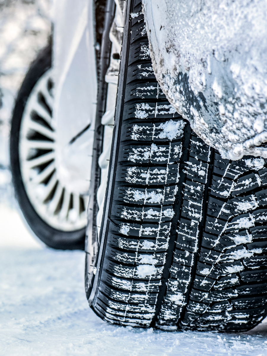 Snow-covered tire on a car in winter conditions