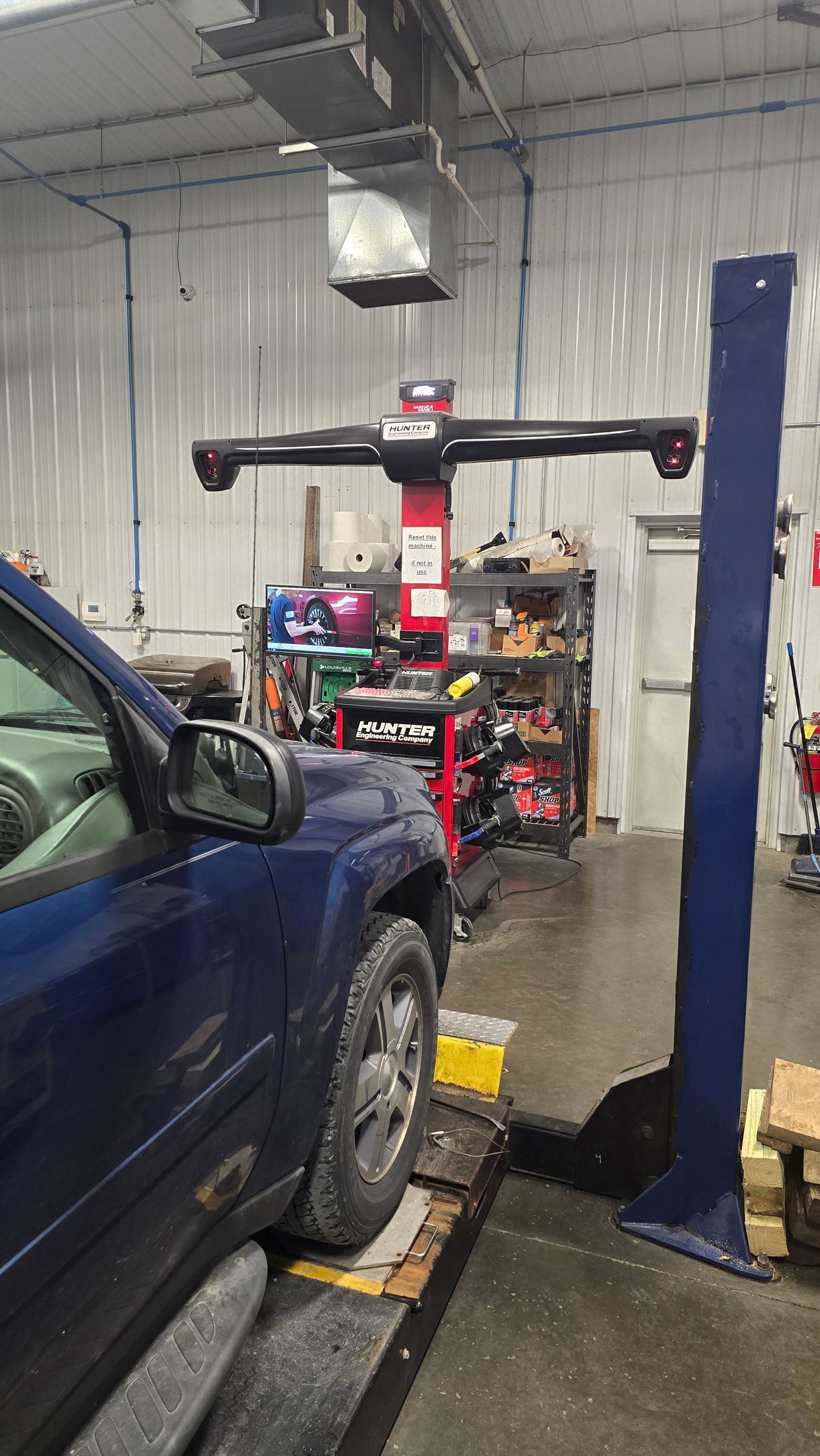 Car wheel on an alignment machine with a digital alignment screen in the background
