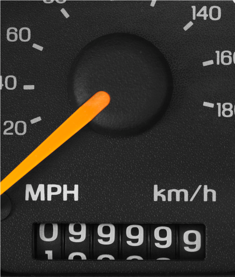 Car dashboard speedometer with orange needle and odometer reading 099999
