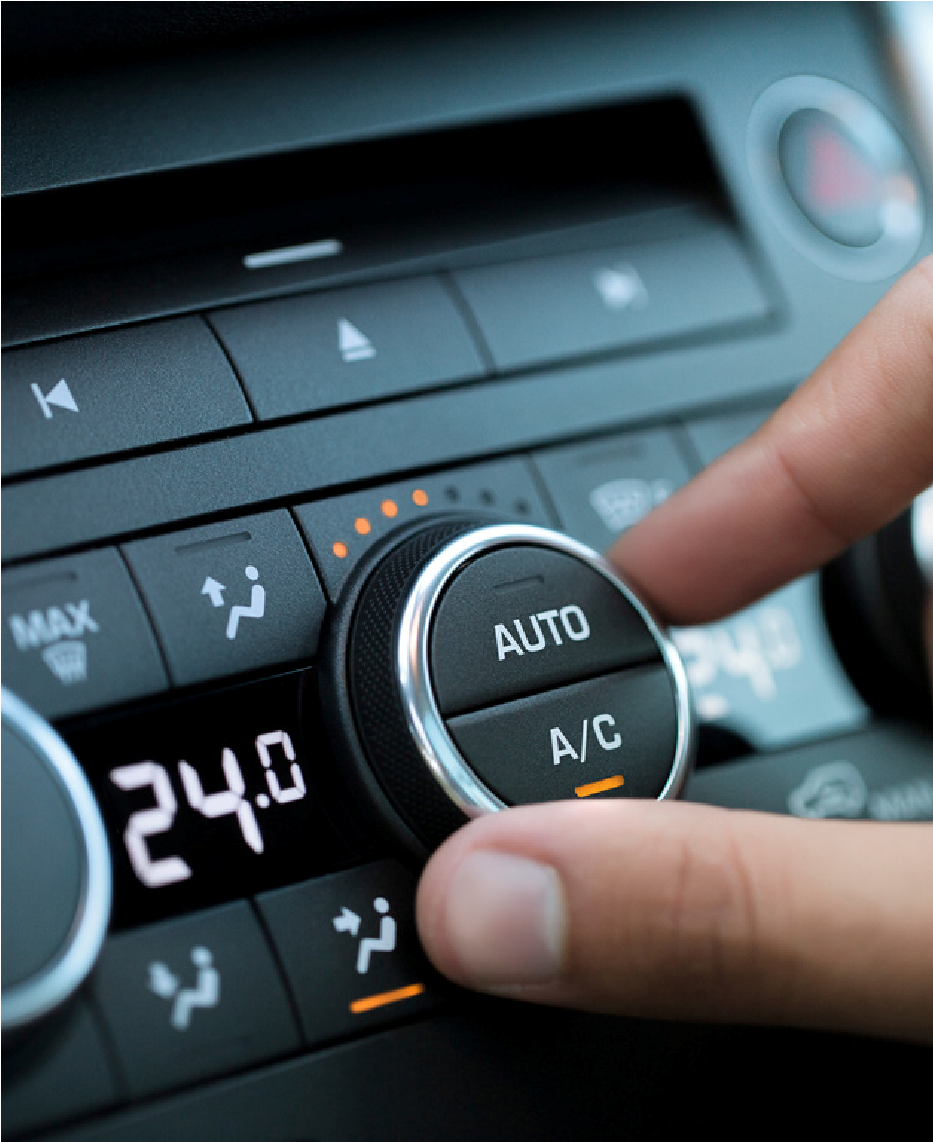 Hand adjusting a car climate control dial set to AUTO and A/C, with the temperature at 24.0°C